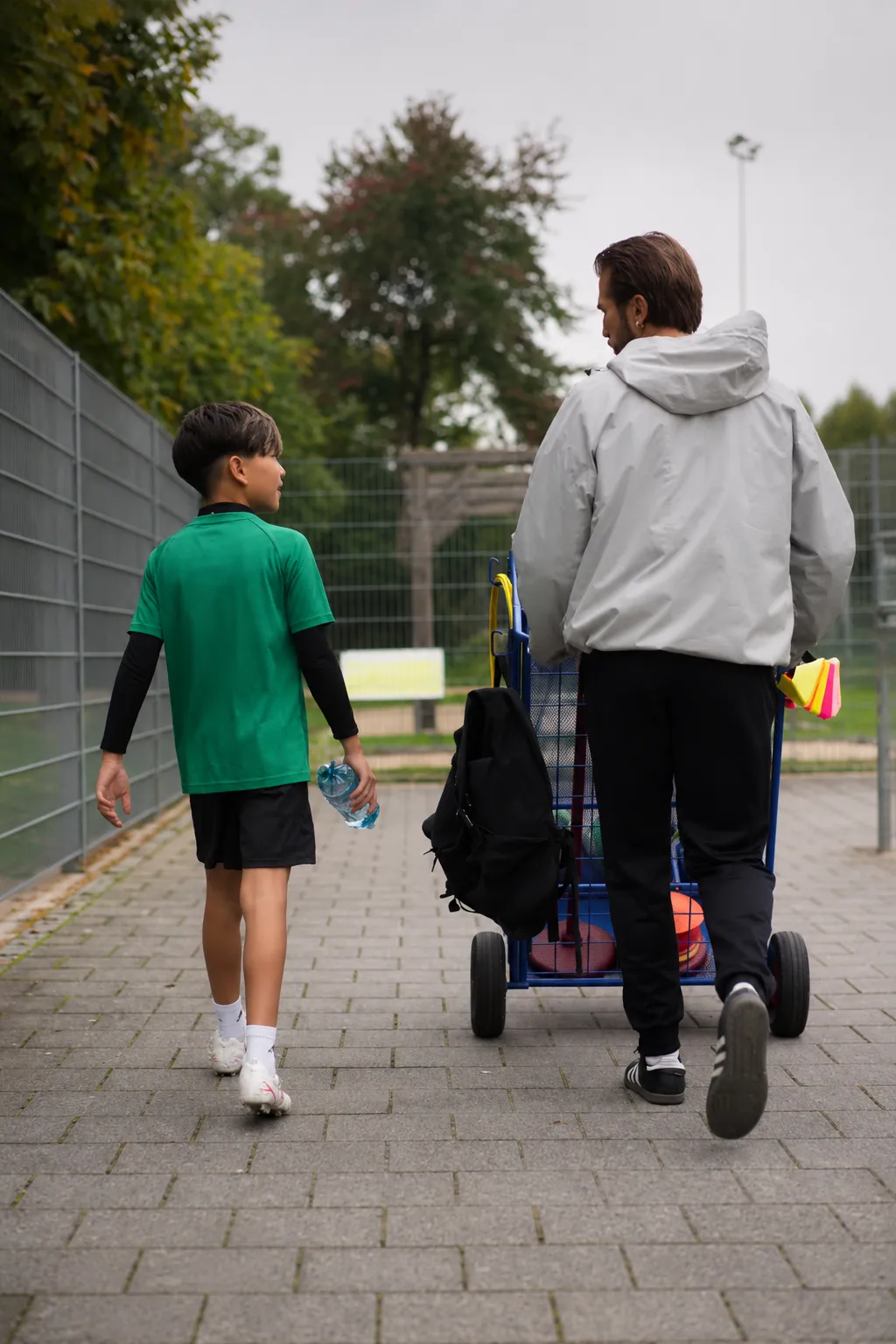 Persönliche Betreuung im Nachwuchstraining, Trainer und Spieler verlassen den Sportplatz